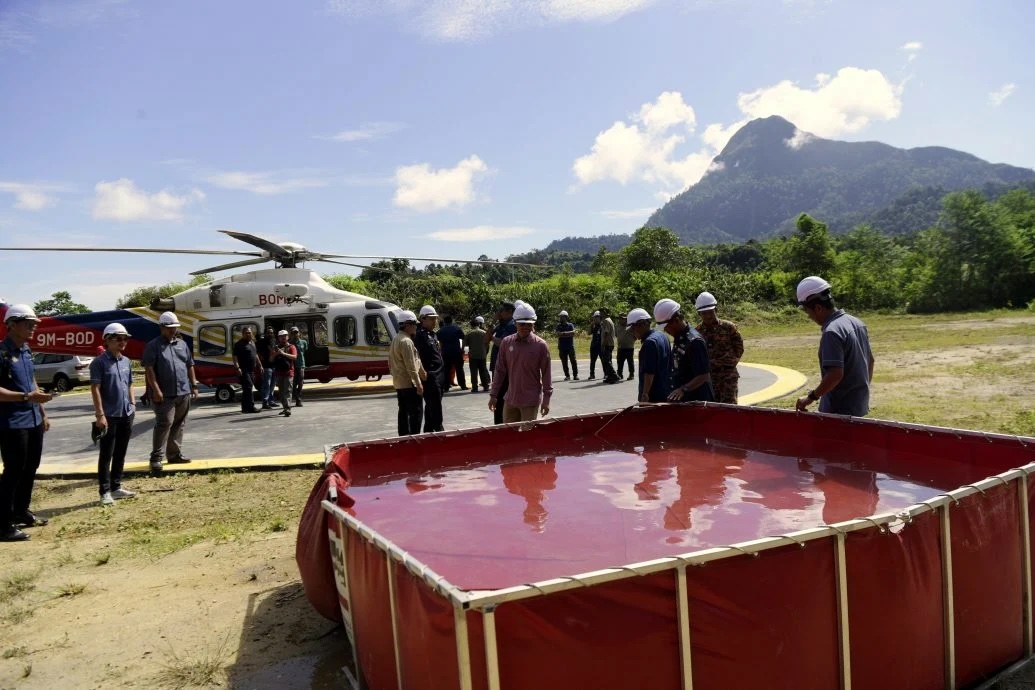 Penolong Pengarah (Seksyen Ladang Hutan dan Inovasi), Jabatan Perhutanan Perak, Mohamad Farhan Sukiman (kiri) melihat takungan air pada Program Ujikaji Tapak Pendaratan Helikopter dan Telaga Tiub bagi Menentang Kebakaran Hutan Negeri Perak di Hutan Simpanan Kekal Kenderong Daerah Hutan Hulu Perak hari ini.